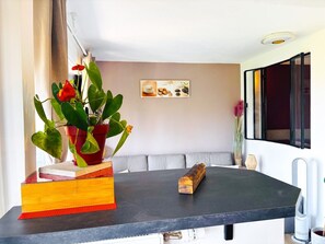 Eine moderne Küche mit dunkler Arbeitsplatte, einem Blumentopf, einem Buch und einem kleinen Dekoelement.
