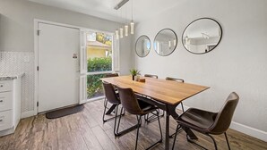 A dining area with a wooden table, four chairs, and two wall-mounted mirrors. - NEW Camelback 352 Resort-style Stay Near Old Town (Scottsdale)