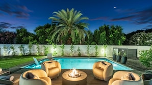 A pool area with a fire pit, lounge chairs, and a palm tree. - NEW The Barrington Ultra-luxe Designer Estate (Scottsdale)