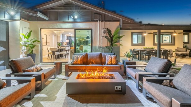 An outdoor living area with a fire feature, seating, and a view into the house. - NEW The Barrington Ultra-luxe Designer Estate (Scottsdale)