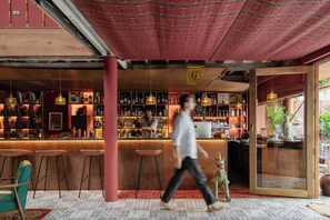 Eine Bar mit Barhocker, einer Theke und Regalen voller Flaschen.