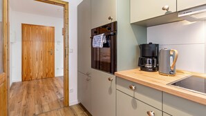Una cucina con una macchina da caffè Bosch, un bollitore e un forno integrato.