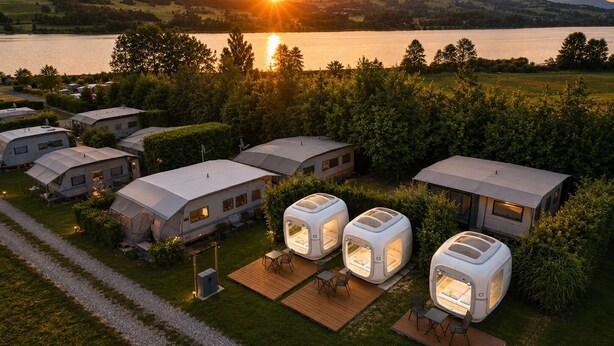 A campsite with RVs and dome-shaped tents, surrounded by greenery and a lake. - Cubes am Irrsee - Self Check-In (Fischhof)