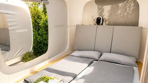 A compact, modern sleeping area with a bed, pillows, and a window. - Cubes am Irrsee - Self Check-In (Fischhof)