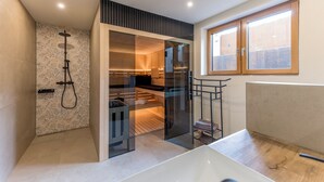 A modern bathroom with a shower, glass-enclosed walk-in closet, and a window.