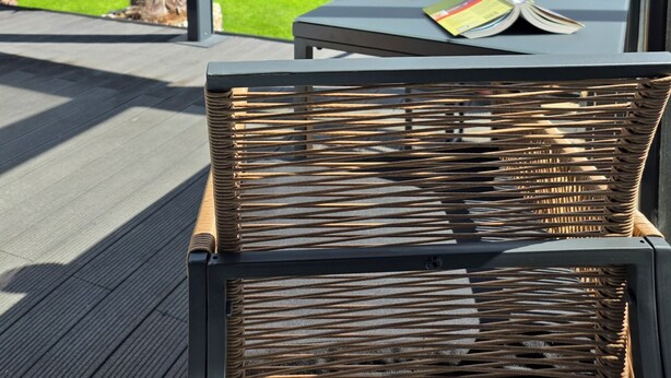 A wicker chair with a glass table, a wine glass, and a book on the table. - All-In Rhein-Main - Pool, Hot Tub, Sauna, Fitness Center & Workspace! (Ginsheim-Gustavsburg)
