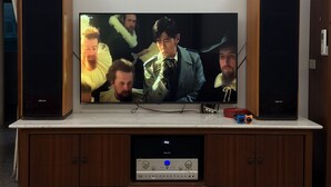 A flat-screen TV mounted on a wooden cabinet with a soundbar below it. - HeartBnb Villa (Taitung)