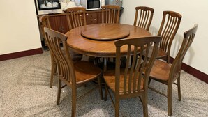 A dining area with a round wooden table and six wooden chairs. - HeartBnb Villa (Taitung)