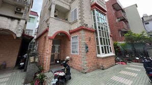 A multi-story building with a brick facade, balconies, and a gated entrance. - HeartBnb Villa (Taitung)
