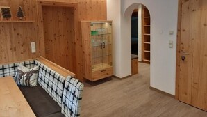 A room with a wooden bench, a glass cabinet, and a wooden door. - Viktoria (Sankt Anton am Arlberg)