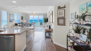 Eine geräumige Küche mit Meerblick, ein Essbereich mit Meerblick und ein Wohnzimmer mit einem großen Fenster zum Meer.