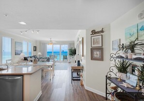 Eine geräumige Küche mit Meerblick, ein Essbereich mit Meerblick und ein Wohnzimmer mit einem großen Fenster zum Meer.