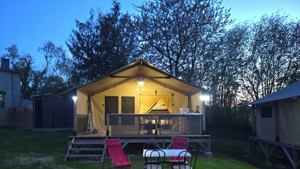 A tented accommodation with a dining area, a slide, and a table with chairs. - The Safari Lodge Tent We offer you unusual accommodation (Souleuvre en Bocage)