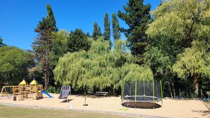 A playground with a swing set, slide, and trampoline. - The Safari Lodge Tent We offer you unusual accommodation (Souleuvre en Bocage)