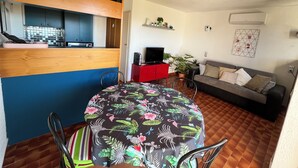 A compact living space with a kitchen area, a dining table, a sofa, and a TV. - Charming 2-room apartment with magnificent sea view (Grosseto-Prugna)