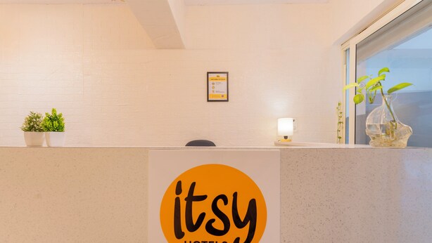 En receptionsdisk med en logotyp, en krukväxt, ett inramat certifikat och ett fönster med utsikt.