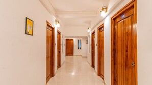 A hotel hallway with wooden doors, a framed picture on the wall, and a sign indicating room number 203. - Itsy Hotels Cozy Retreat - Near Mysore Palace & Zoo (Mysore)