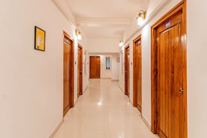 A hotel hallway with wooden doors, a framed picture on the wall, and a sign indicating room number 203. - Itsy Hotels Cozy Retreat - Near Mysore Palace & Zoo (Mysore)