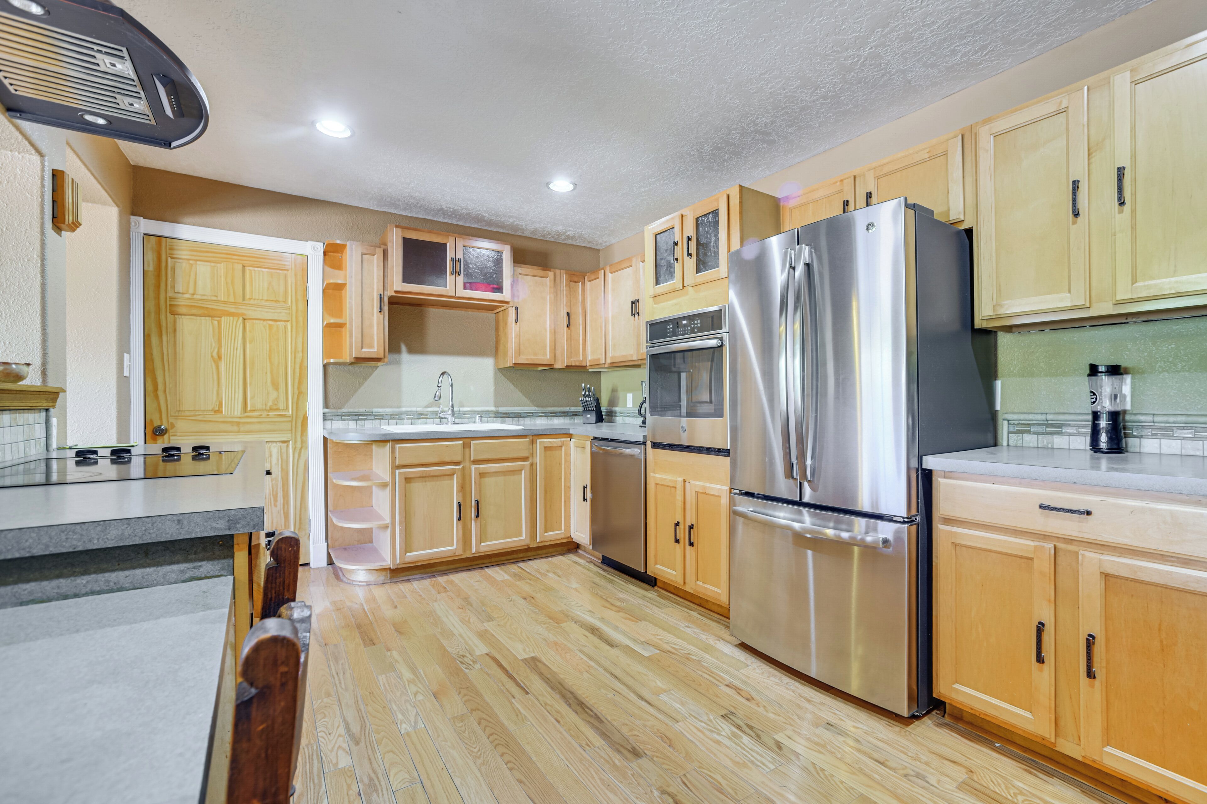 A kitchen with wooden cabinets, stainless steel appliances, and a tiled backsplash.