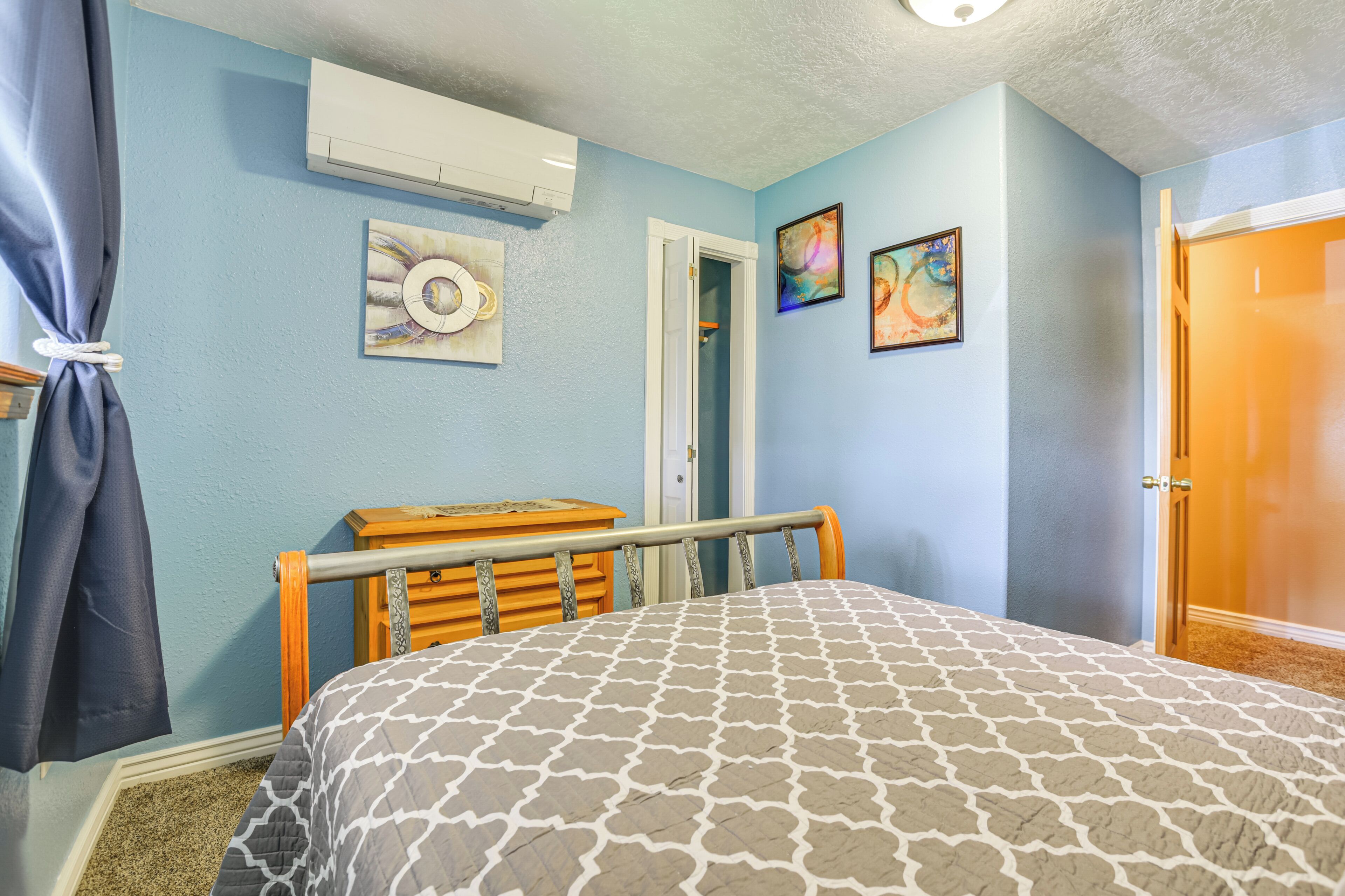 Un dormitorio con cama, cómoda, puerta y decoración en la pared.