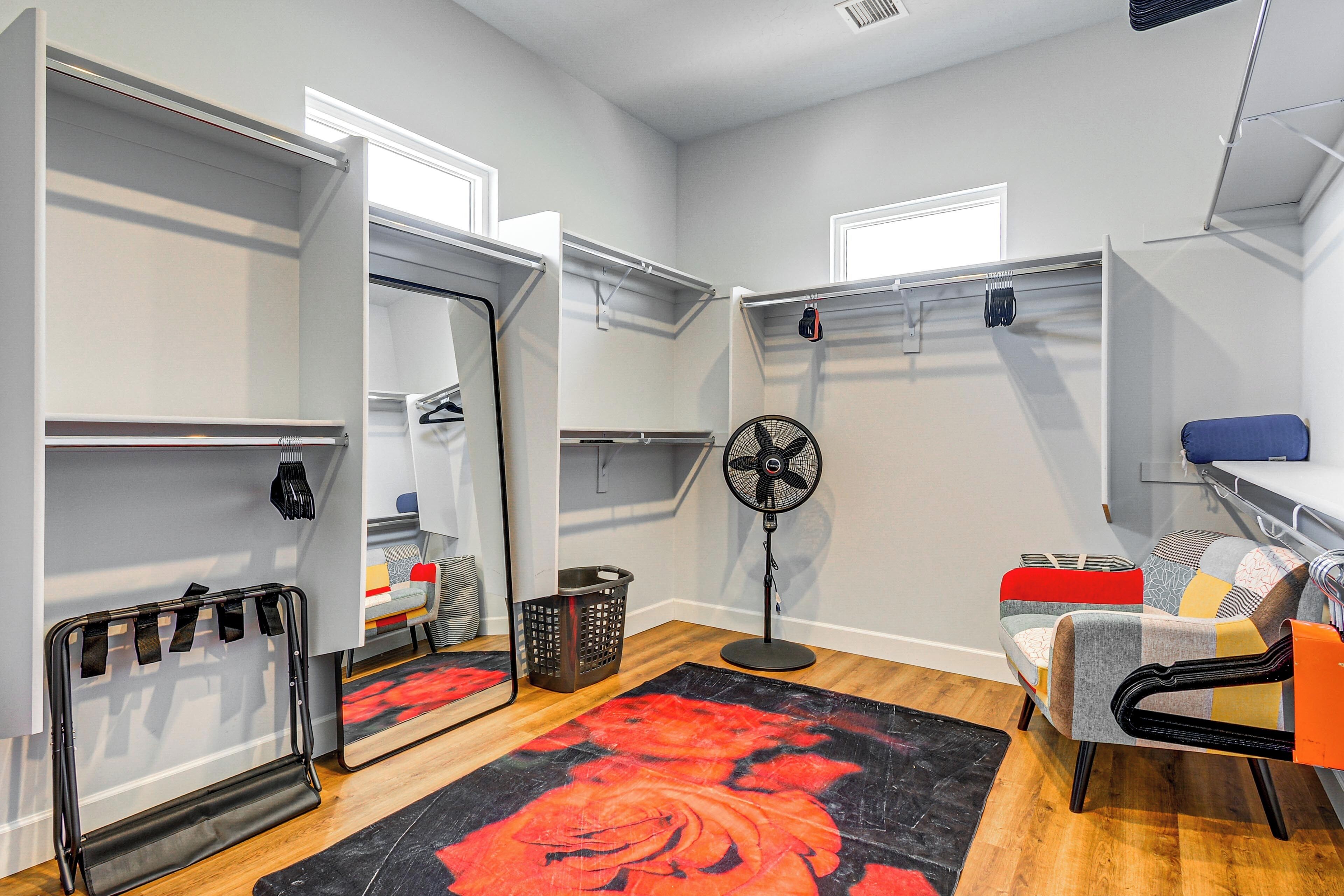 A compact room with a bed, a chair, a fan, and a small table.