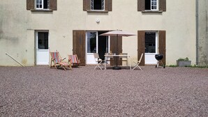 A building with three windows, a door, and a gravel driveway. - Le Village by Interhome (Meuvaines)