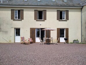 A building with three windows, a door, and a gravel driveway. - Le Village by Interhome (Meuvaines)
