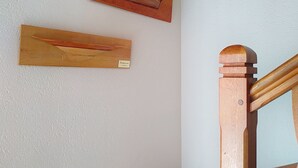 A staircase with wooden handrails and a white wall with two wooden plaques. - Le Village by Interhome (Meuvaines)