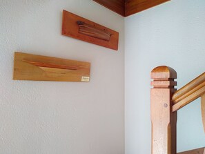 A staircase with wooden handrails and a white wall with two wooden plaques. - Le Village by Interhome (Meuvaines)