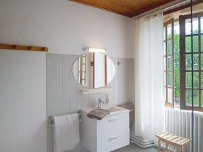 A bathroom with a white sink, mirror, and towel rack. - Le Village by Interhome (Meuvaines)