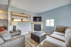 Una sala de estar con chimenea, televisor y un espejo grande.