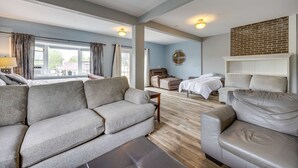 Ein großzügiger Wohnbereich mit Sofa, Bett und Kamin.