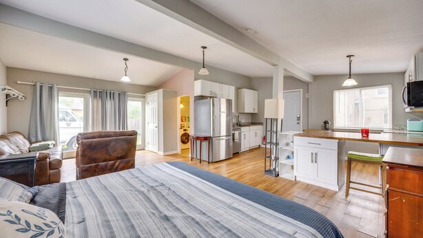 A spacious room with a large bed, a seating area, a kitchen, and a dining area. - Couples Outdoor Retreat Near Garden of the Gods (Colorado Springs)