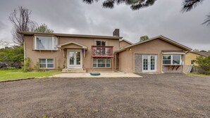 A two-story house with a balcony, a front porch, and a driveway. - Couples Outdoor Retreat Near Garden of the Gods (Colorado Springs)