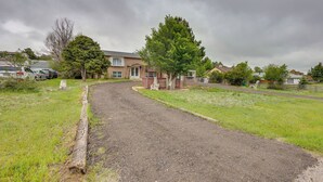 A residential driveway leading to a house with a large tree in the front yard. - Couples Outdoor Retreat Near Garden of the Gods (Colorado Springs)