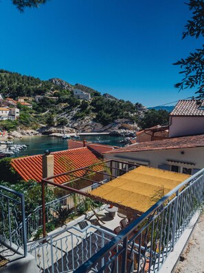 A coastal view with a balcony overlooking a marina, a hillside with buildings, and a clear blue sky. - Calanca - Niolon - Renovated, sea view, 1 min walk (Le Rove)