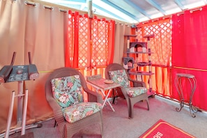 A room with wicker furniture, a small table, a cat tree, and a treadmill. - Next to Wine Rd! Apt w/ Balcony in Fredericksburg (Fredericksburg)