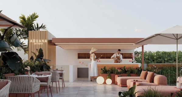 An outdoor seating area with tables and chairs, a bar area with a bartender, and a sign reading 'ADUANA SKYBAR'.
