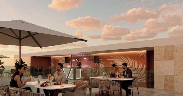 Un área de comedor al aire libre con mesas redondas, sillas y sombrillas.
