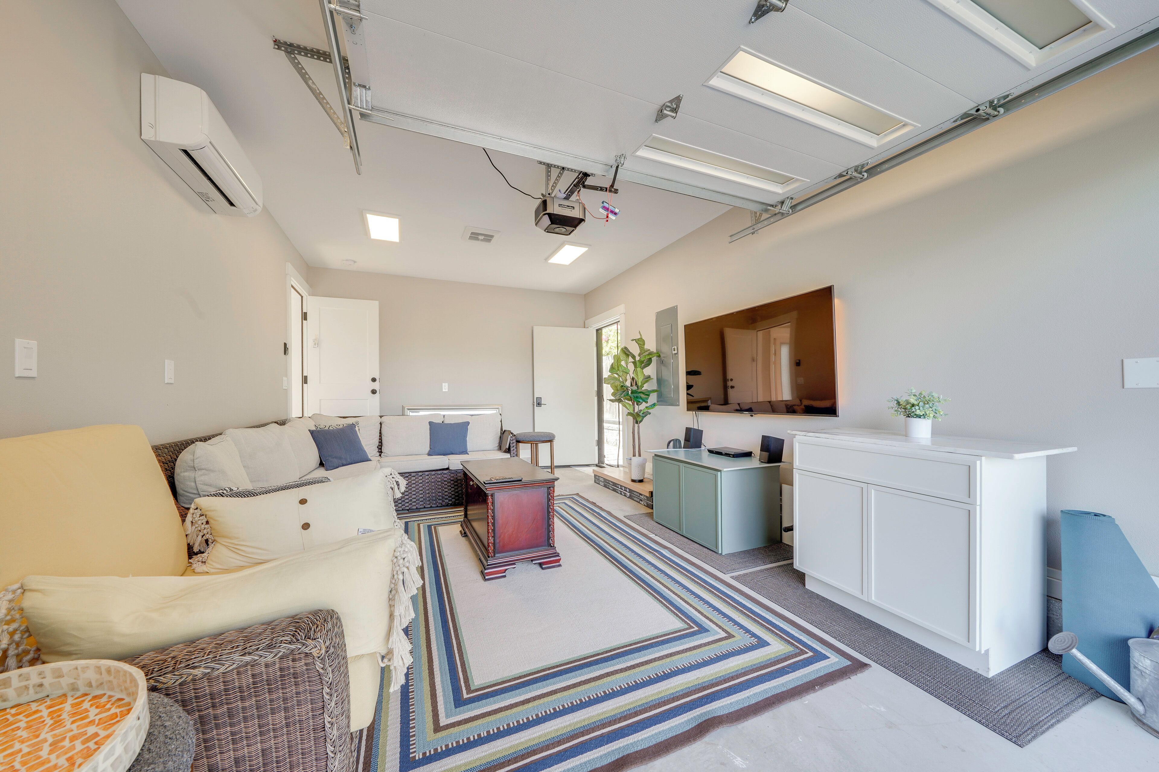 A modern living room with a sofa, a coffee table, and a kitchen area with a counter and cabinets.