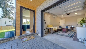 A modern home interior with a living area, kitchen, and a large sliding door entrance. - Rooftop Deck + Private Patio! West Seattle Home (Seattle)