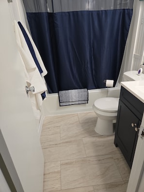 Ein Badezimmer mit Toilette, Badewanne und Handtuchhalter.
