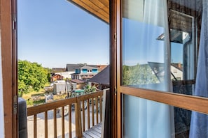 A balcony with a view of houses and greenery.