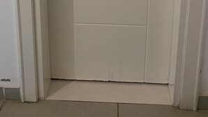 En stängd, vit dörr med ett silverfärgat handtag och ett nyckelhål.