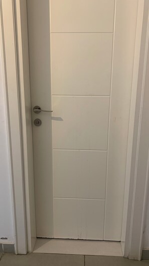 A closed white door with a silver handle and a keyhole. - Harmony Park Luxury Stay Near U.S. Embassy (Accra)
