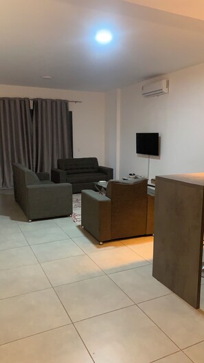A living room with a sofa, armchair, and a coffee table. - Harmony Park Luxury Stay Near U.S. Embassy (Accra)
