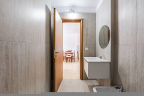 Ein modernes Badezimmer mit Waschbecken, Spiegel und Dusche.