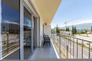 Ein Balkon mit Blick auf eine Baustelle, einen klaren Himmel und entfernte Gebäude.