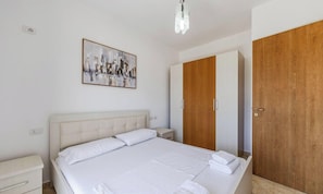 Ein Schlafzimmer mit einem Bett, einem Nachttisch, einem Holzschrank und einem Gemälde an der Wand.