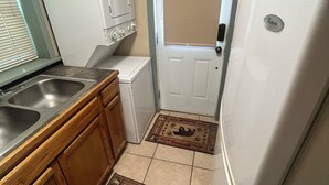 A compact kitchen with a sink, wooden cabinets, a white refrigerator, and a door with a window. - Stan's Hideaway in Tropic 9 miles to Bryce Canyon, Tucked away & private, Unique (Tropic)